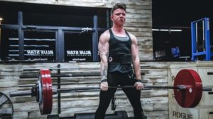 a person performing a heavy deadlift in a powerlifting/old school gym