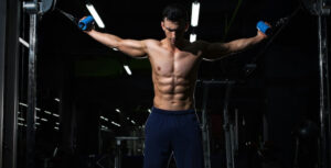 a man at the gym holding the handles of a double crossover machine